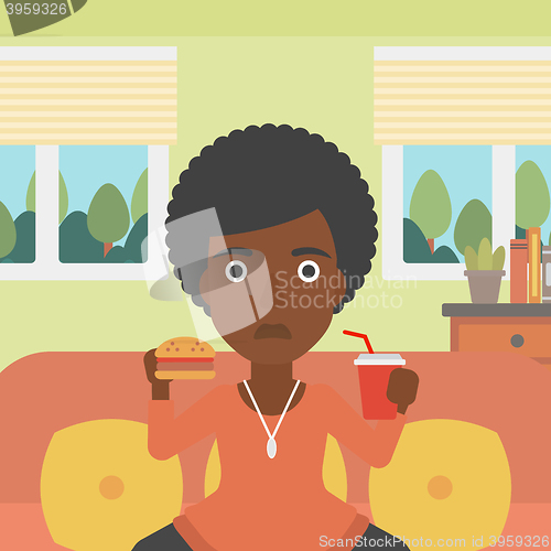 Image of Woman eating hamburger. 