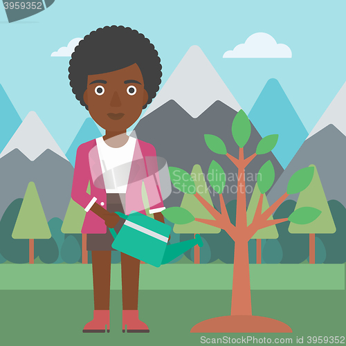 Image of Woman watering tree with light bulbs.