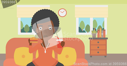 Image of Woman eating hamburger. 
