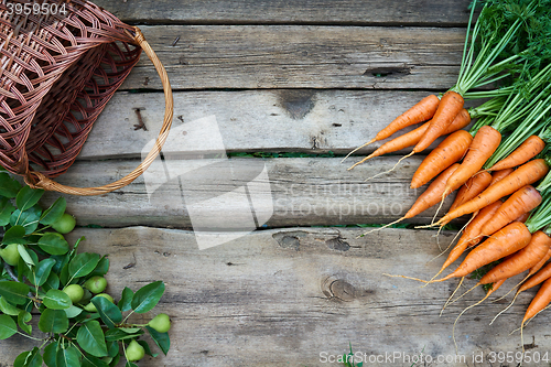 Image of Fresh carrots bunch and tomatoes on rustic wooden background