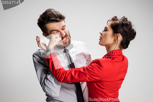 Image of The business man and woman conflicting on a gray background