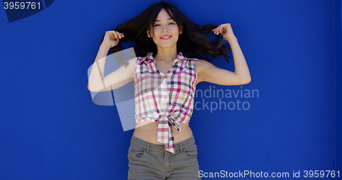 Image of Smiling happy young woman holding her hair