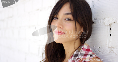 Image of Serene woman with long brown hair stares at camera