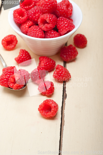 Image of bunch of fresh raspberry on a bowl and white table