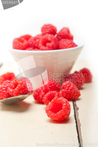 Image of bunch of fresh raspberry on a bowl and white table