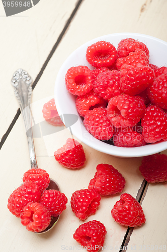 Image of bunch of fresh raspberry on a bowl and white table