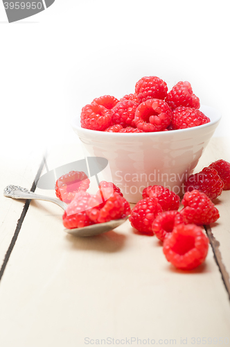 Image of bunch of fresh raspberry on a bowl and white table