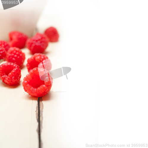 Image of bunch of fresh raspberry on a bowl and white table