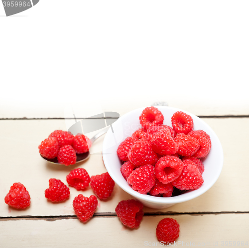 Image of bunch of fresh raspberry on a bowl and white table