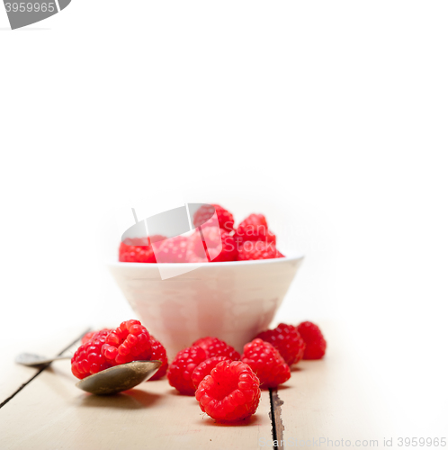 Image of bunch of fresh raspberry on a bowl and white table