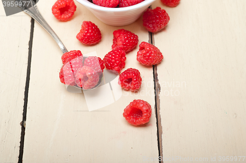 Image of bunch of fresh raspberry on a bowl and white table