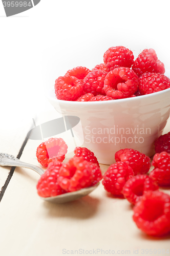 Image of bunch of fresh raspberry on a bowl and white table