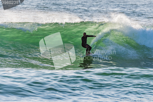 Image of Long boarder surfing the waves at sunset