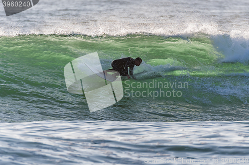 Image of Long boarder surfing the waves at sunset