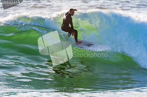 Image of Long boarder surfing the waves at sunset