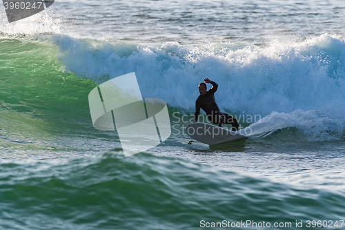 Image of Long boarder surfing the waves at sunset