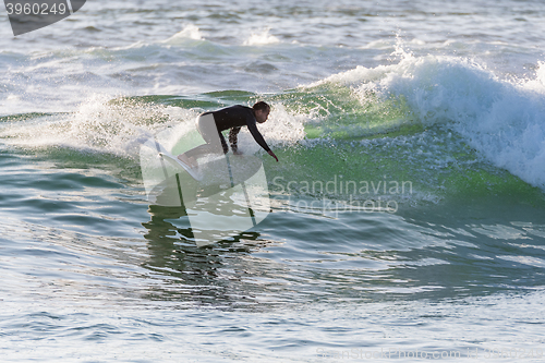 Image of Long boarder surfing the waves at sunset