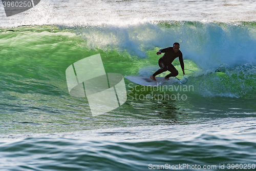 Image of Long boarder surfing the waves at sunset