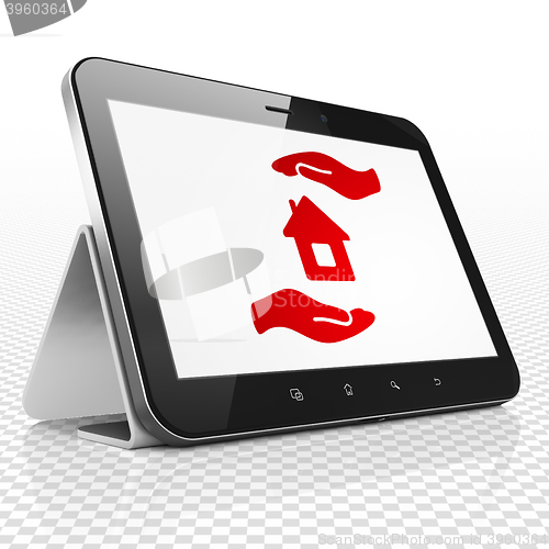 Image of Insurance concept: Tablet Computer with House And Palm on display