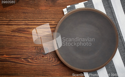 Image of napkin and dark plate on wooden table