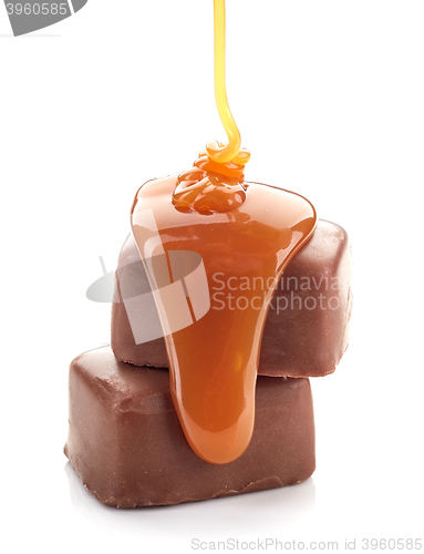 Image of caramel sauce flowing on chocolate candies