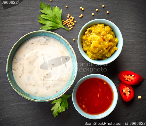 Image of various sauces on black background