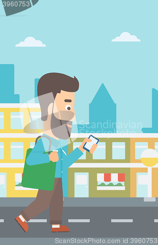 Image of Man walking with smartphone.