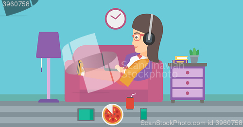 Image of Woman lying on sofa with many gadgets.