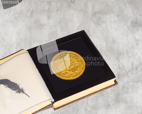 Image of Medal with the image of the book and a Laurel branch