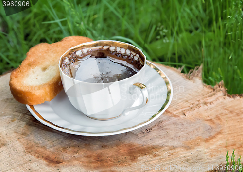 Image of Still life: a Cup of black coffee in the garden.