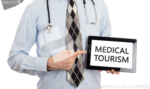 Image of Doctor holding tablet - Medical tourism