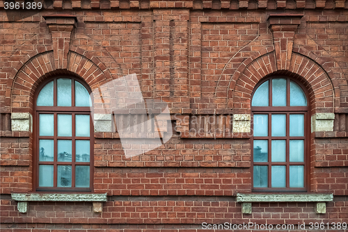 Image of Two window on a brown wall.