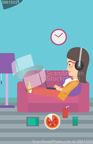 Image of Woman lying on sofa with many gadgets.