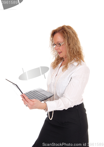 Image of Business woman standing and working with laptop.