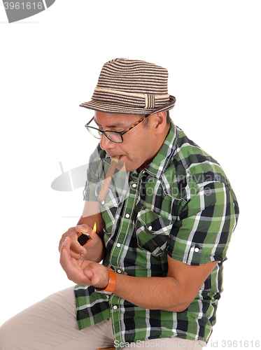 Image of Hispanic man lightning his cigar.