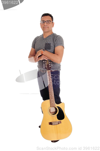 Image of Hispanic man standing with guitar.