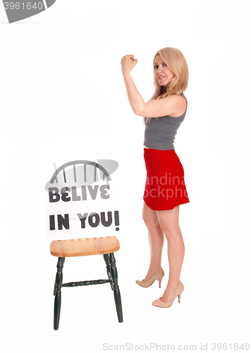 Image of Blond woman holding sign BELIEVE IN YOU.