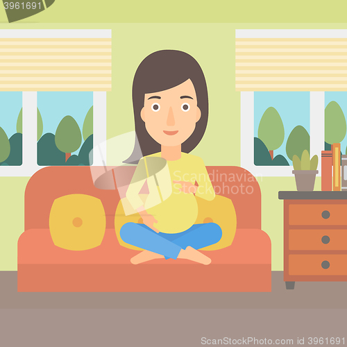 Image of Pregnant woman sitting on sofa.