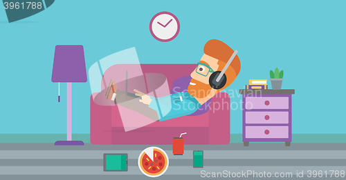 Image of Man lying on sofa with many gadgets.