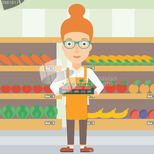 Image of Supermarket worker with box full of apples.