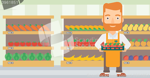 Image of Supermarket worker with box full of apples.