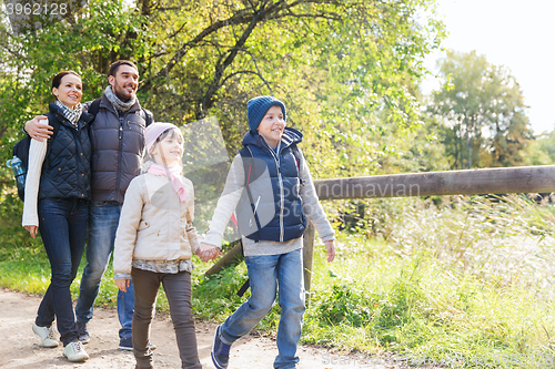 Image of happy family with backpacks hiking in woods