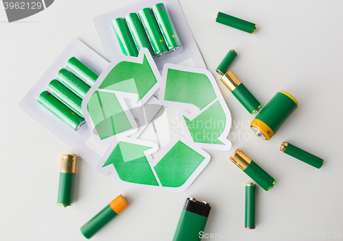 Image of close up of batteries and green recycling symbol