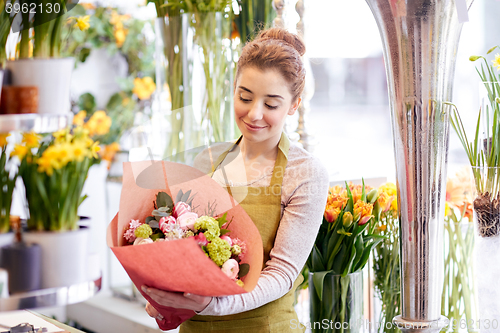 Image of smiling florist woman with bunch at flower shop
