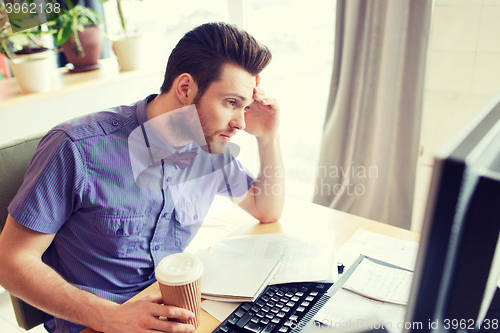 Image of creative male worker with computer drinking coffee