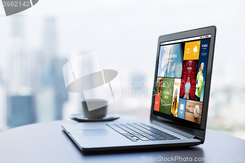 Image of close up of laptop and coffee cup on office table