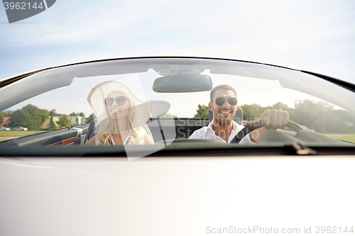 Image of happy man and woman driving in cabriolet car