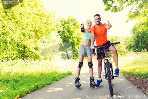 Image of couple on rollerblades and bike showing thumbs up