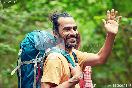 Image of group of smiling friends with backpacks hiking