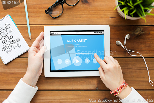 Image of close up of woman with tablet pc on wooden table